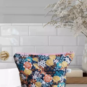 Tousse matelassée en diagonale avec des différentes fleurs de tout les couleurs. Fermeture par Zippe